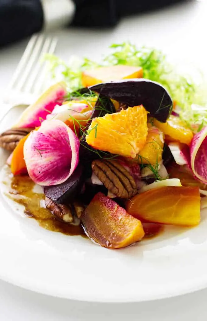 Serving of beet salad on plate with fork and napkin