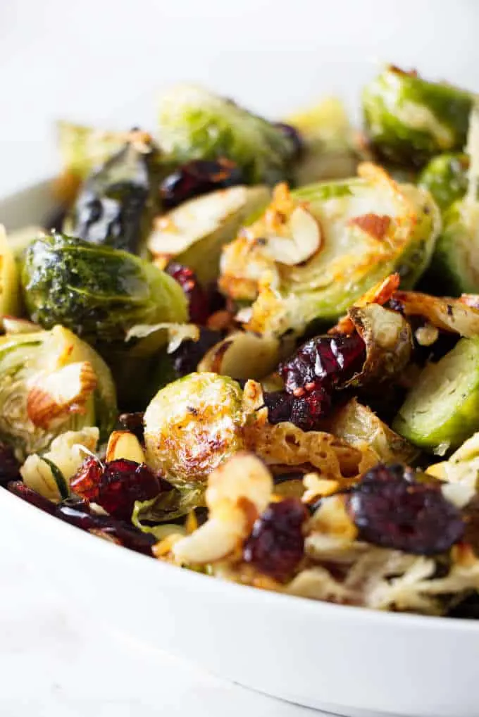 A bowl of roasted Brussels sprouts with parmesan, cranberries, and almonds