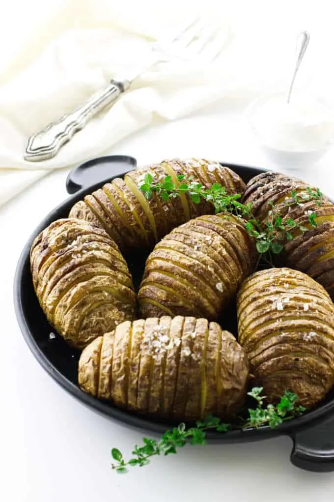 Plate with six prepared garlic-butter hasselback potatoes