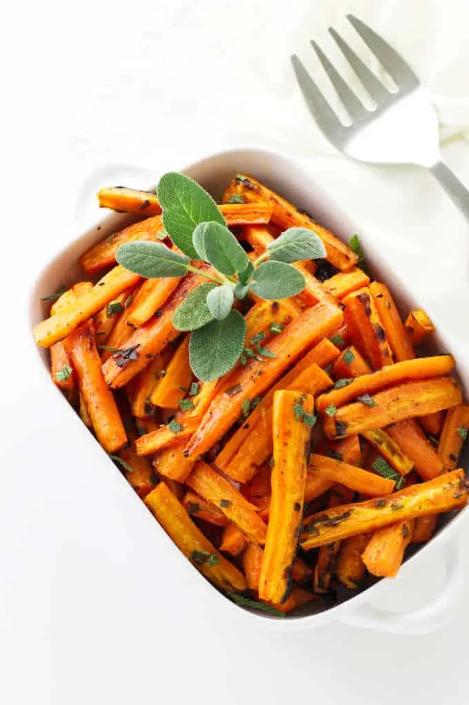 Overhead view of honey roasted carrots with fresh sage