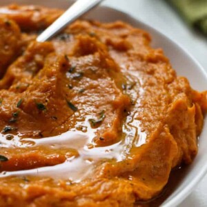 Close up photo of instant pot mashed sweet potatoes with a drizzle of butter