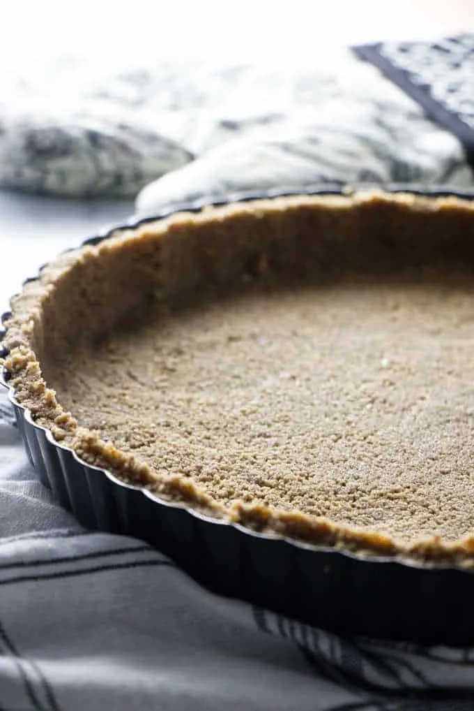 A brown sugar pecan pie crust in a tart pan.