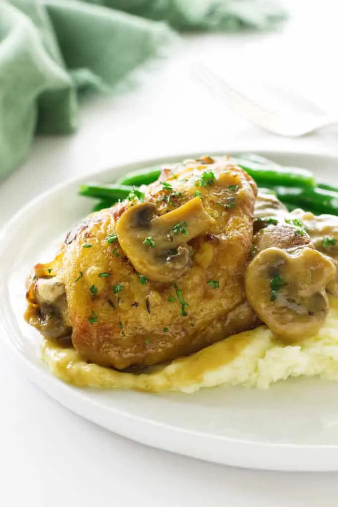 Chicken in mushroom cream sauce on a plate with mashed potatoes
