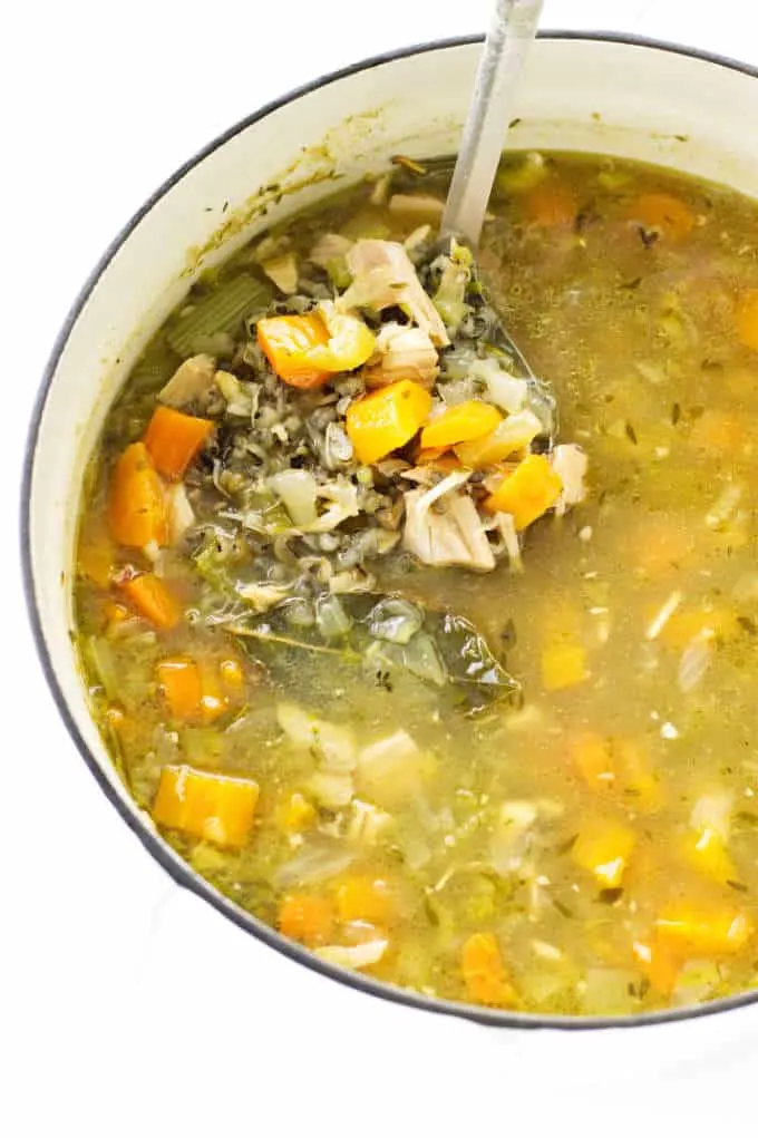 A stock pot of chicken soup with wild rice and vegetables.