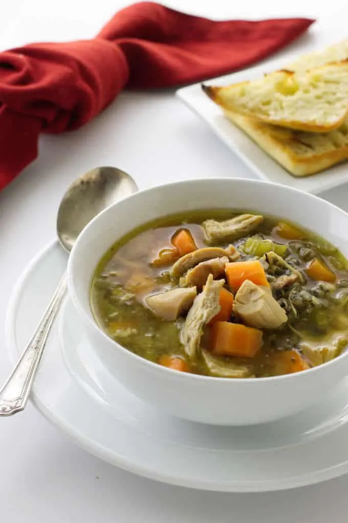 Chicken soup with wild rice and vegetables in a serving bowl.