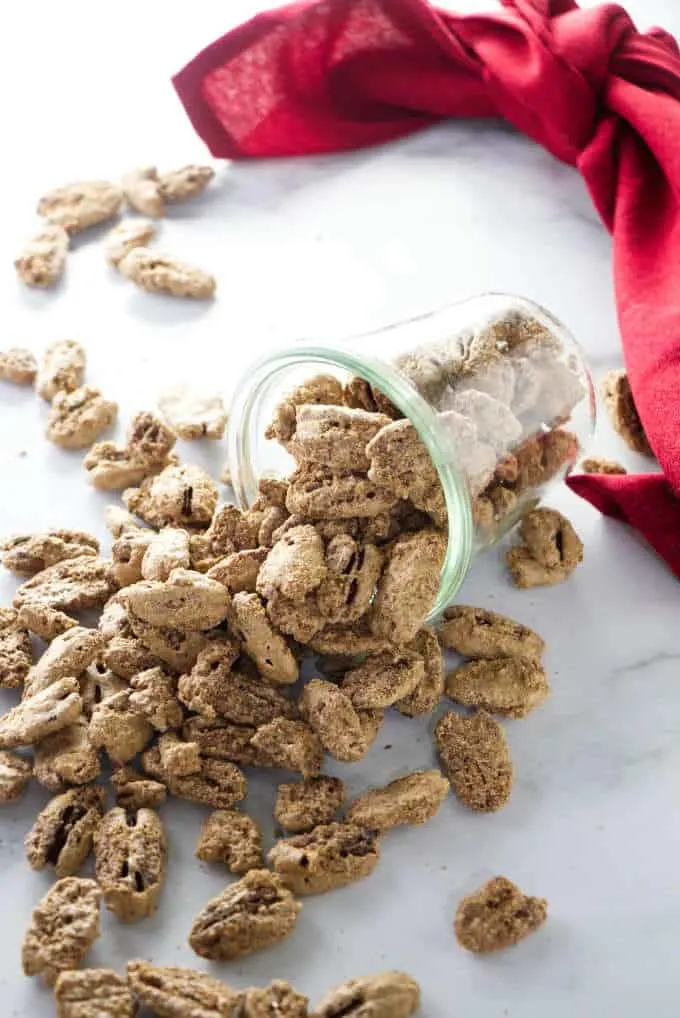 A jar of cinnamon sugar candied pecans and a red napkin.