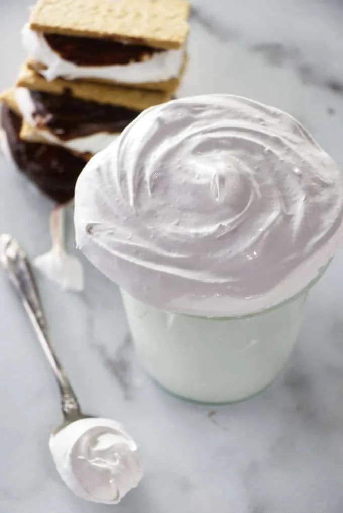 A jar of homemade marshmallow fluff and some s'mores.