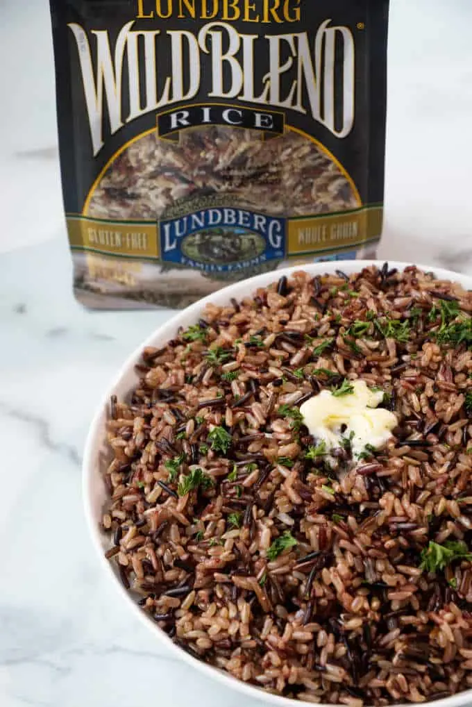 A dish of wild blend rice with a package of Lundberg wild rice blend.