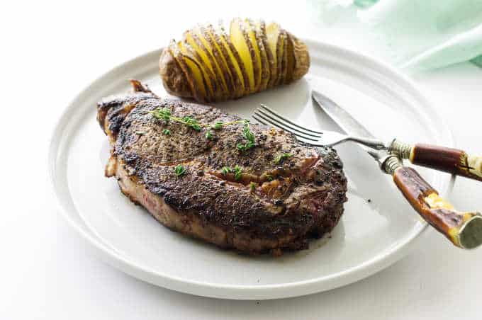 seared and oven cooked ribeye steak with hasselback potato
