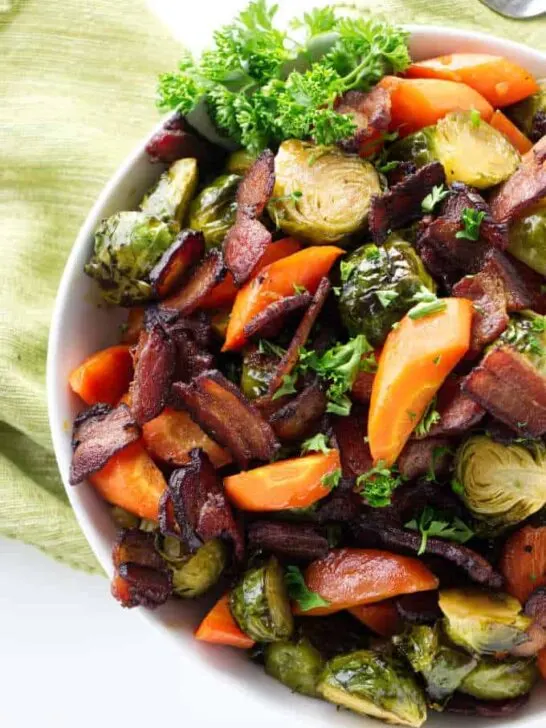 Roasted Brussels Sprouts with carrots and bacon in a bowl.