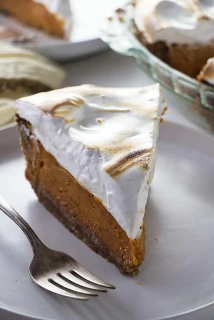 A closeup of a slice of Southern sweet potato pie with toasted marshmallow fluff on top.