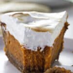 A closeup of a partially eaten Southern sweet potato pie with homemade marshmallow fluff.