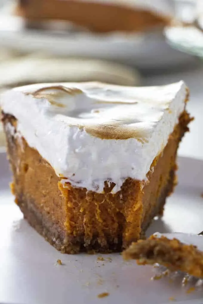 A closeup of a partially eaten Southern sweet potato pie with homemade marshmallow fluff.