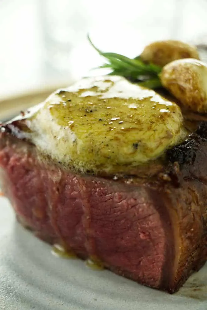 A steak with a pat of melting truffle butter.