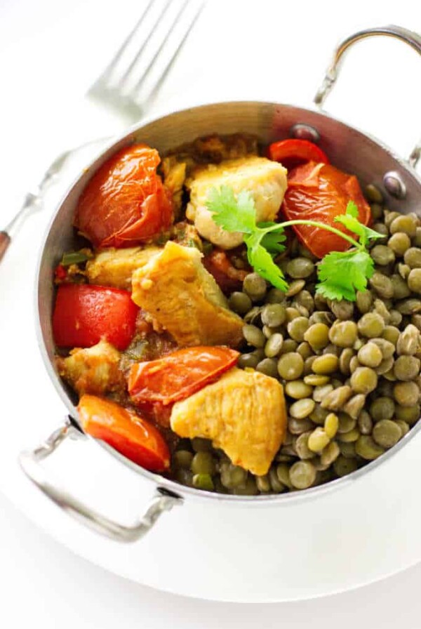 A bowl of chicken Karahi and lentils.