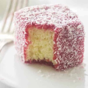close up of a serving of raspberry lamington on a plate with fork