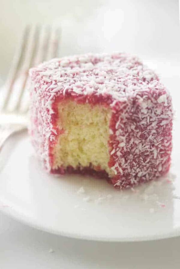 close up of a serving of raspberry lamington on a plate with fork