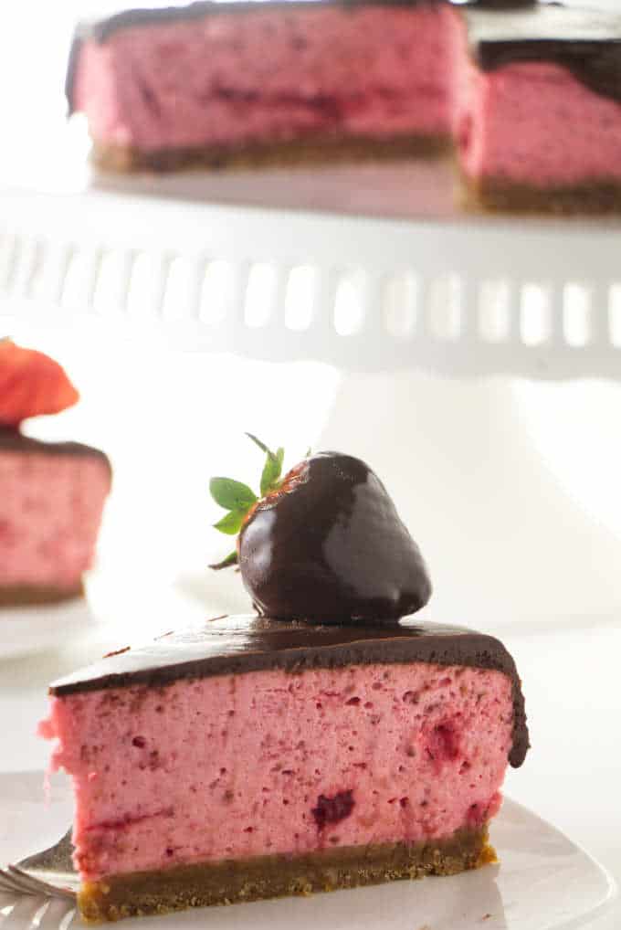 Close up photo of a chocolate covered strawberry cheesecake.