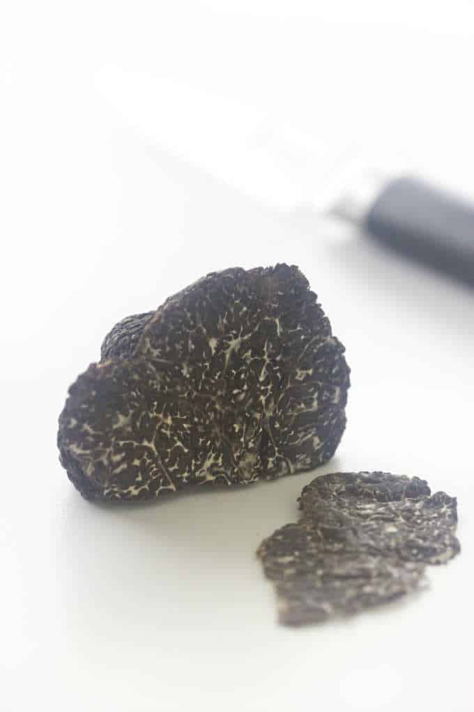 Oregon Black Truffle with a slice cut, knife in background