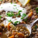 Close up of lentil soup with sour cream and lemon.