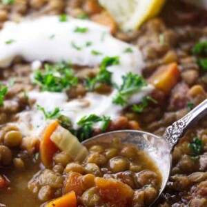 Close up of lentil soup with sour cream and lemon.