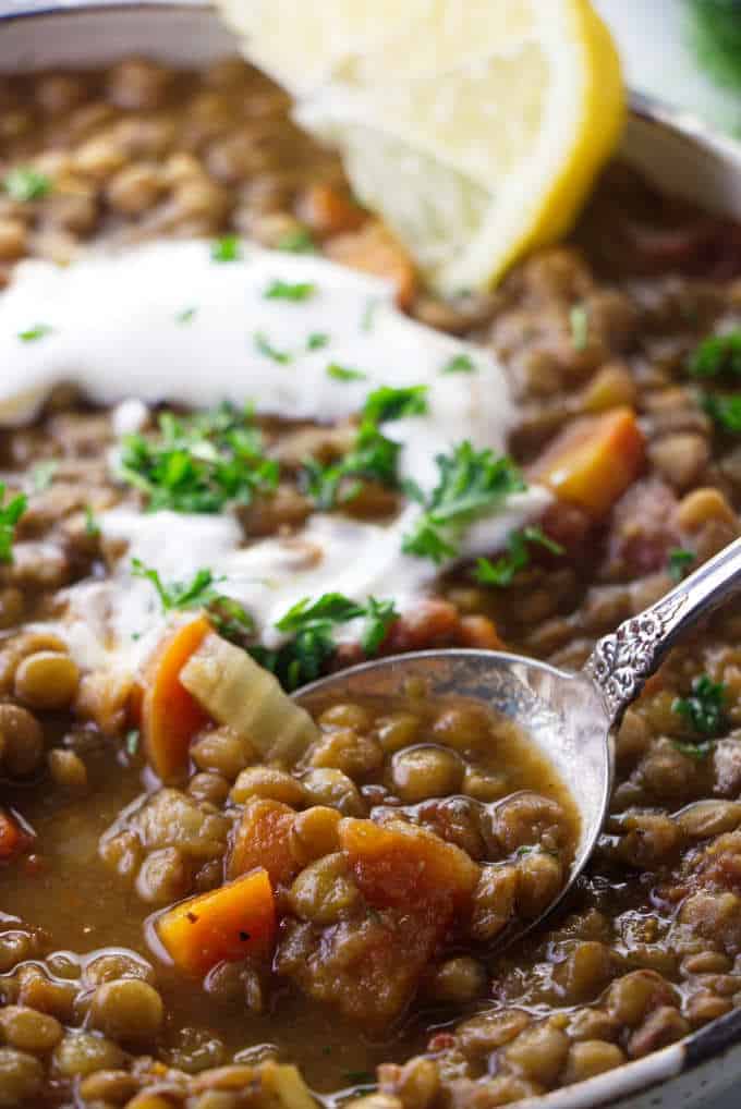 Close up of lentil soup with sour cream and lemon.