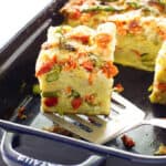 Portion of strata being lifted from the baking dish