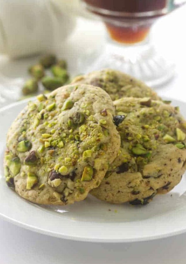 A closeup of pistachio cherry cookies that have dried cherries.