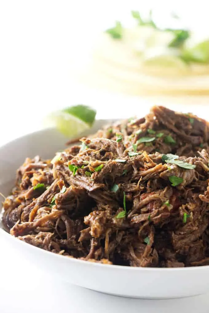 A serving bowl of shredded beef made in the Instant Pot.