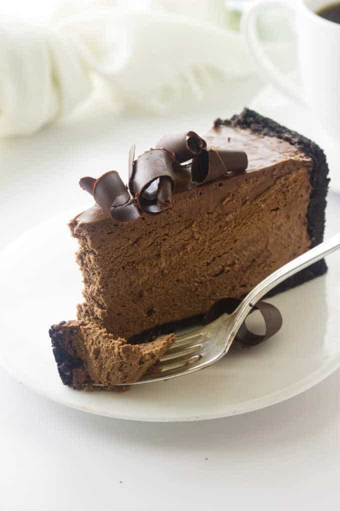 Serving of chocolate cheesecake with a bite on a fork