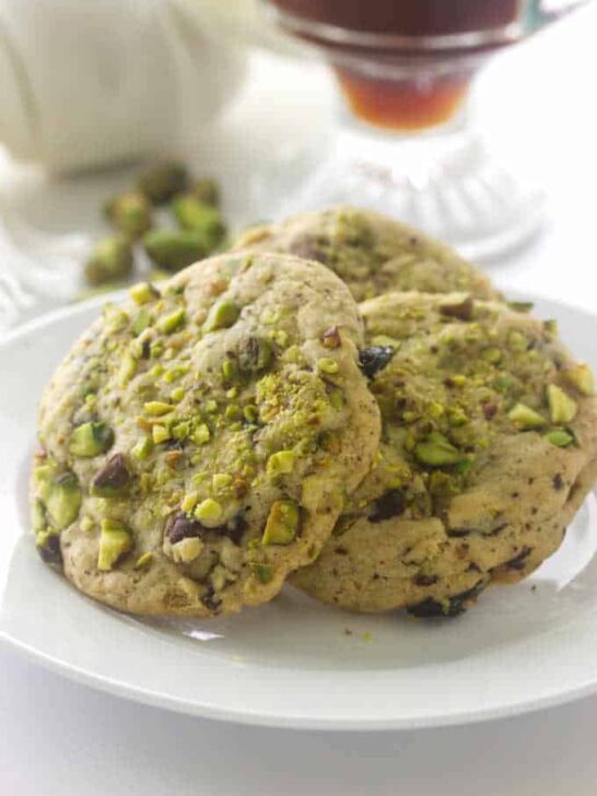 A closeup of pistachio cherry cookies that have dried cherries.