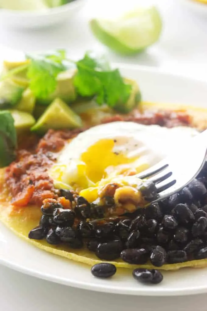 Serving of huevos rancheros with a bite on a fork