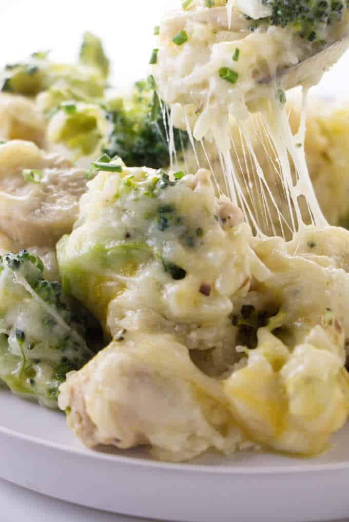 Cheese stretching from a spoon of chicken broccoli and rice casserole.