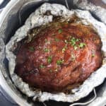 A meatloaf in an instant pot with aluminum foil as a bowl for the drippings.