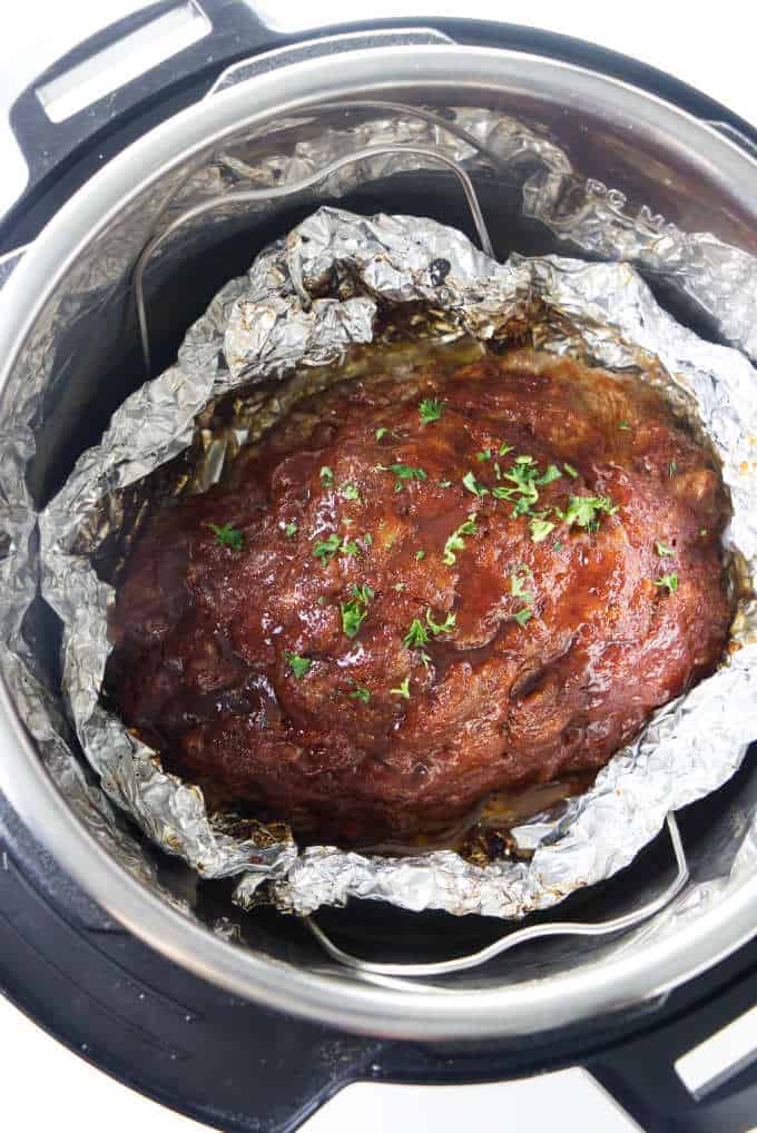 A meatloaf in an instant pot with aluminum foil as a bowl for the drippings.