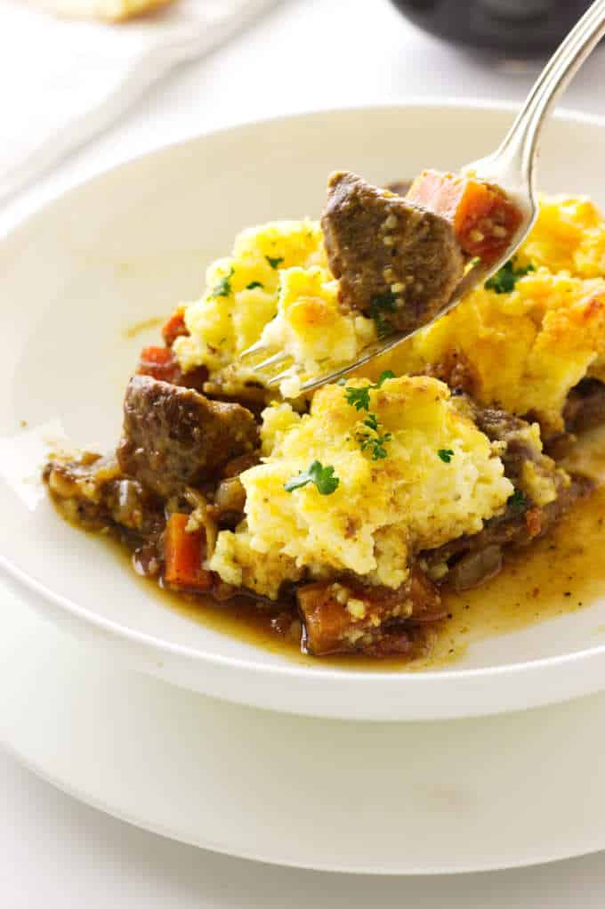 close up view of a serving of lamb ossobuco casserole and a bite on a fork