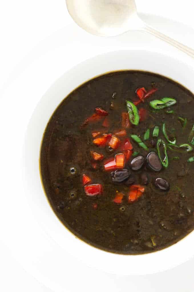 Overhead view of Chipotle Black Bean Soup, garnished with red bell pepper and scallions