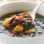 Overhead view of Chipotle Black Bean Soup, garnished with red bell pepper and scallions