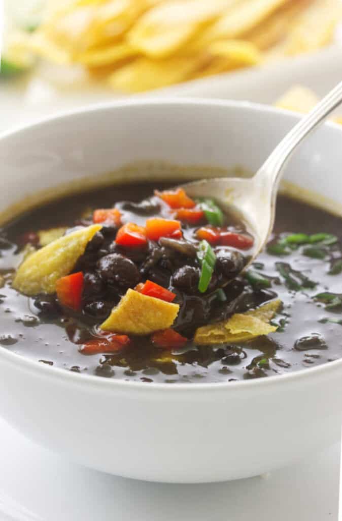 Overhead view of Chipotle Black Bean Soup, garnished with red bell pepper and scallions