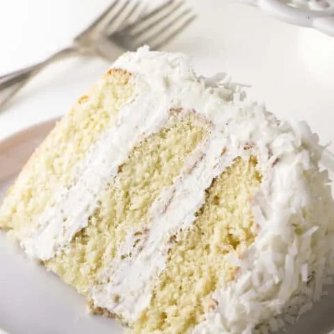A single slice of coconut cake with coconut buttercream.