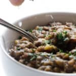 Squirting a lime on a bowl of lentils.