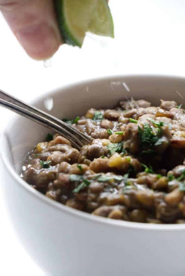 Squirting a lime on a bowl of lentils.