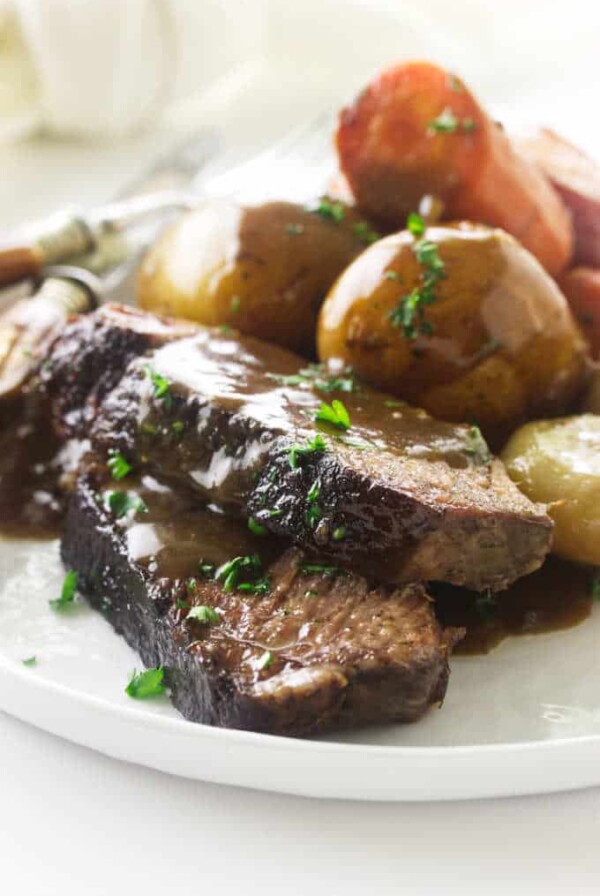 Close up view of a serving of pot roast, potatoes and carrots