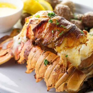 Broiled lobster tail on a serving plate.