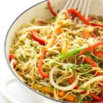 Overhead view of pan of pork yakisoba with spatula