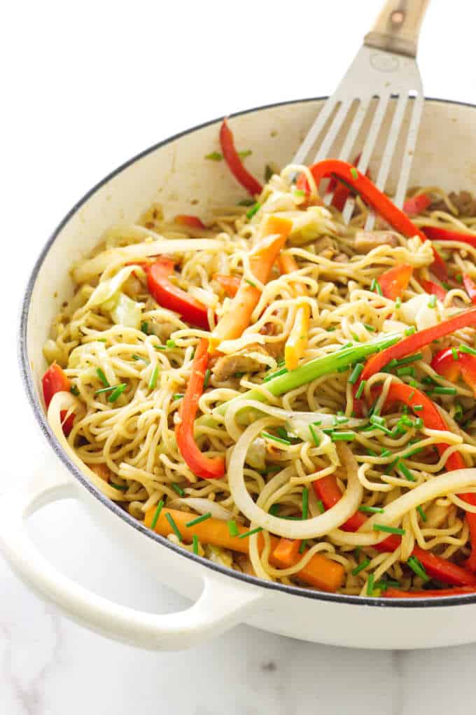 Overhead view of pan of pork yakisoba with spatula