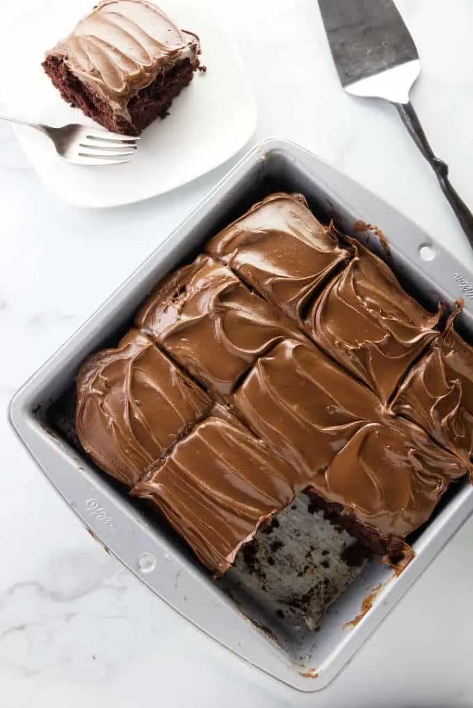 A pan with slices of wacky chocolate cake frosted with chocolate peanut butter frosting.