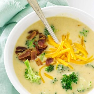 Overhead view of soup, garnished with broccoli, bacon and cheddar