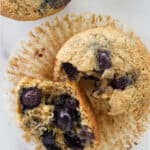 Muffin broke in half showing blueberries inside.