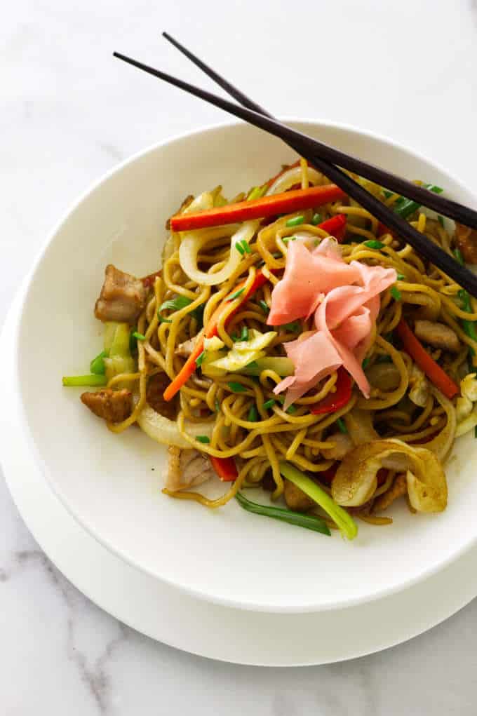 Overhead view of a serving of pork yakisoba with chopsticks